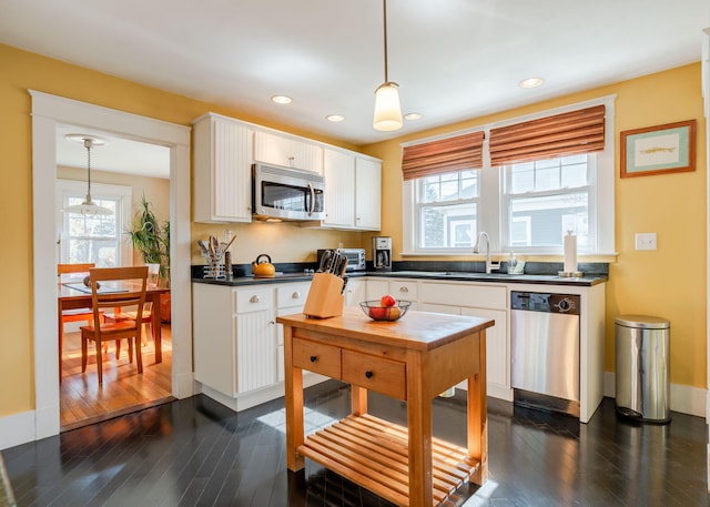 kitchen featuring dark wood finished floors, appliances with stainless steel finishes, white cabinets, and dark countertops