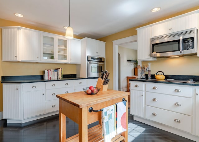 kitchen with dark countertops, white cabinets, stainless steel appliances, and recessed lighting