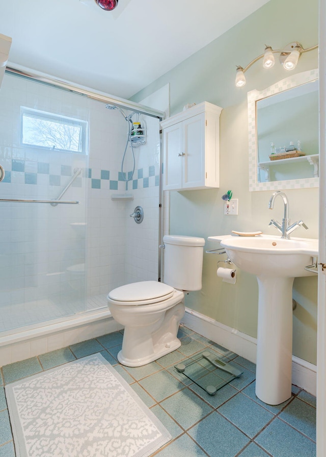 full bath with toilet, baseboards, a shower stall, and tile patterned flooring