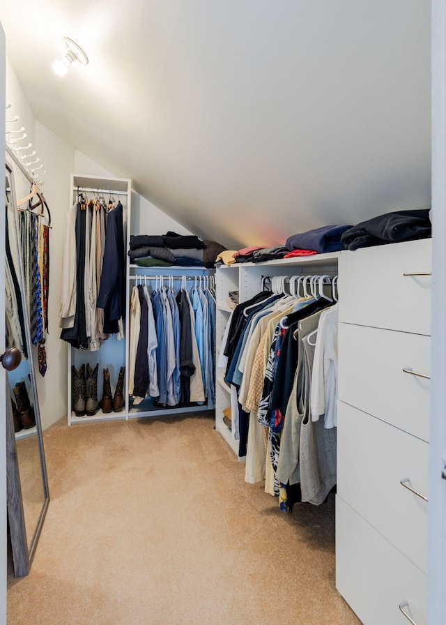 walk in closet with carpet flooring and lofted ceiling