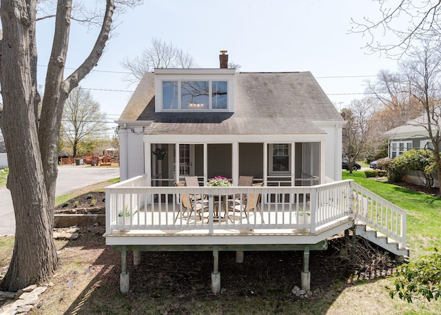 rear view of property with a shingled roof and a chimney