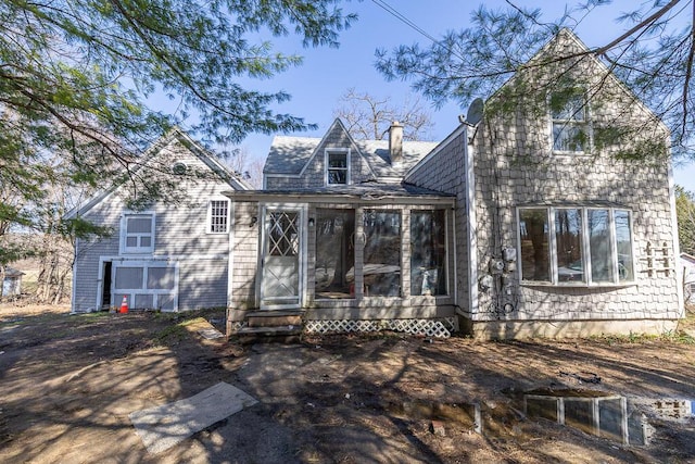 view of front of house with a chimney and a sunroom