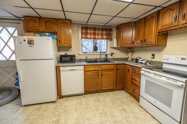 kitchen featuring white appliances, brown cabinets, and a sink