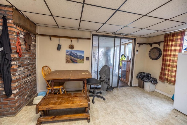 office area featuring baseboards and a paneled ceiling