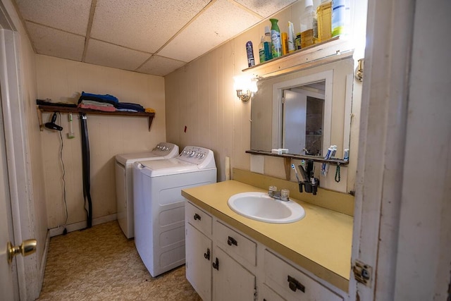 bathroom with vanity, a paneled ceiling, independent washer and dryer, and tile patterned floors