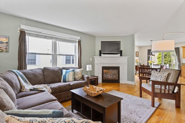 134 Yale St, Portland, ME 04103 - living room with healthy amount of natural light, light wood finished floors, and a glass covered fireplace