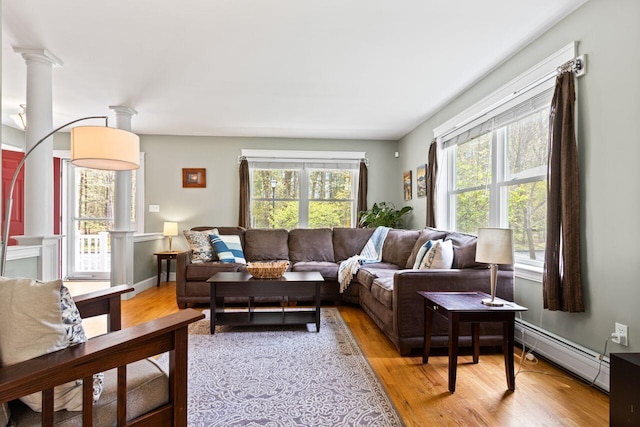 134 Yale St, Portland, ME 04103 - living room featuring a baseboard radiator, light wood-style floors, and ornate columns