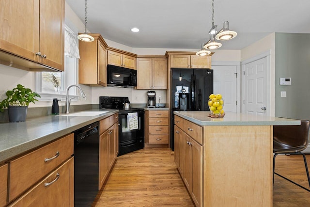 134 Yale St, Portland, ME 04103 - kitchen featuring black appliances, a sink, a kitchen island, light wood-type flooring, and hanging light fixtures