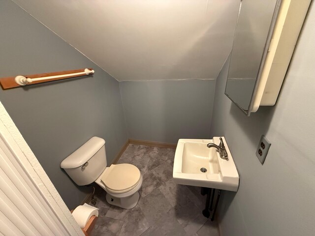 633 Norway Rd, Harrison, ME 04040 - half bathroom with toilet, vaulted ceiling, baseboards, and a sink