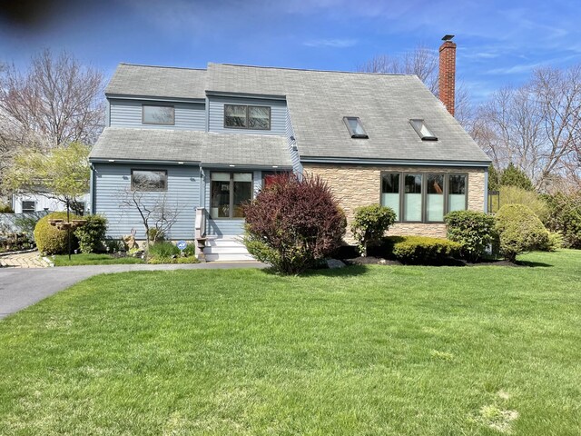 16 Howard Ave Unit 16, Wells, ME 04090 - view of front facade with a chimney, entry steps, roof with shingles, a front lawn, and stone siding