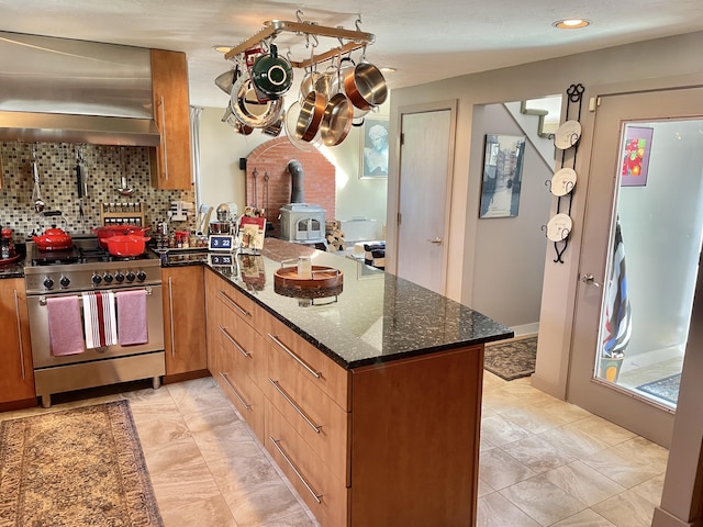 16 Howard Ave Unit 16, Wells, ME 04090 - kitchen with wall chimney range hood, stainless steel stove, a wood stove, a peninsula, and decorative backsplash