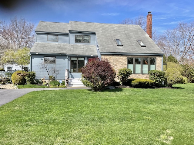 16 Howard Ave Unit 16, Wells, ME 04090 - view of front facade with a chimney, a front yard, entry steps, a shingled roof, and stone siding