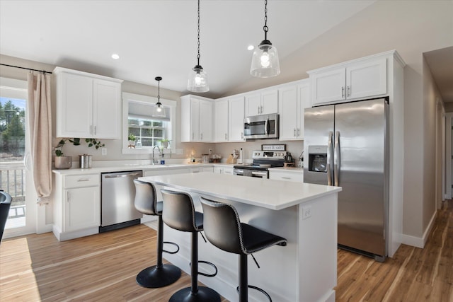 kitchen with light countertops, light wood-style flooring, stainless steel appliances, and white cabinetry
