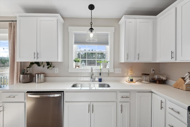 kitchen with stainless steel dishwasher, white cabinets, and a sink