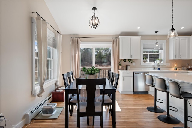 dining space with recessed lighting, a baseboard radiator, light wood finished floors, and a wealth of natural light