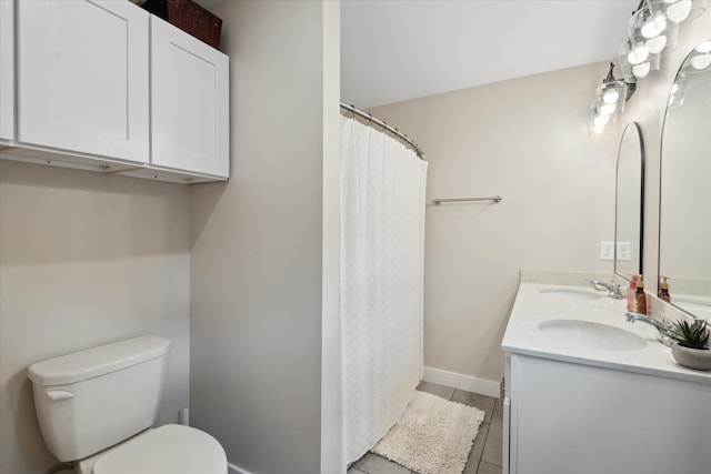 bathroom with a sink, toilet, double vanity, and a shower with shower curtain