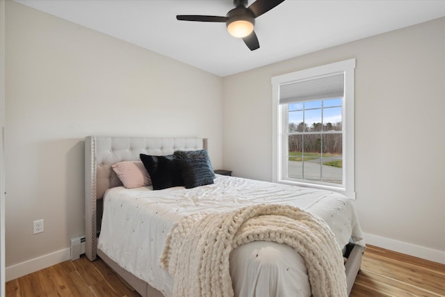 bedroom featuring baseboards, a ceiling fan, and wood finished floors