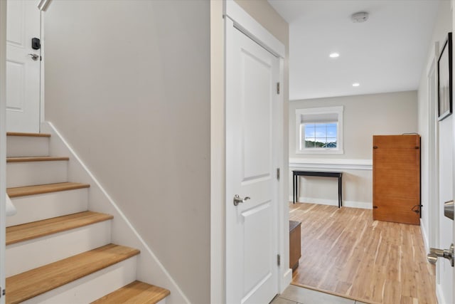 stairway with recessed lighting and wood finished floors