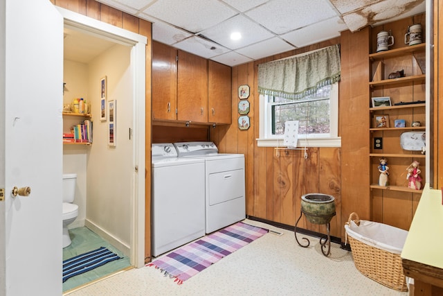washroom with baseboards and washer and clothes dryer