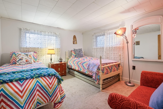 bedroom with ornamental molding and carpet floors