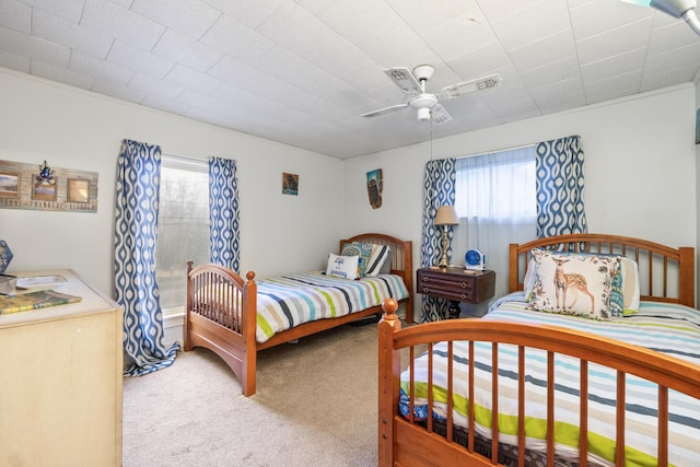 bedroom with carpet flooring, a ceiling fan, and multiple windows