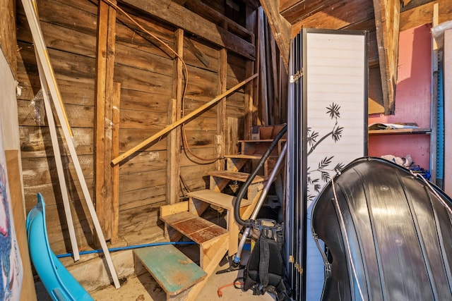 stairway featuring wooden walls