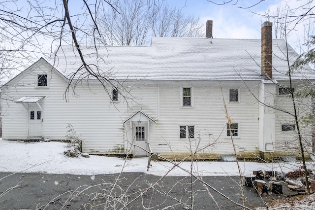 exterior space with a shingled roof and a chimney