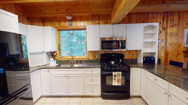 86 Webb Cove Dr, Lowell, ME 04493 - kitchen featuring beam ceiling, wood walls, and black appliances