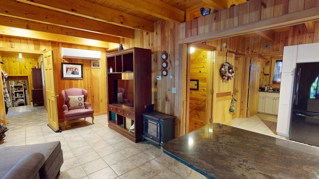 86 Webb Cove Dr, Lowell, ME 04493 - living room featuring beamed ceiling, a wood stove, wooden ceiling, light tile patterned flooring, and wooden walls