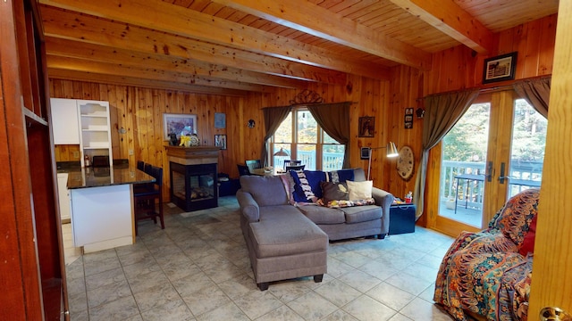 86 Webb Cove Dr, Lowell, ME 04493 - living room featuring beamed ceiling, wooden walls, a tiled fireplace, and french doors