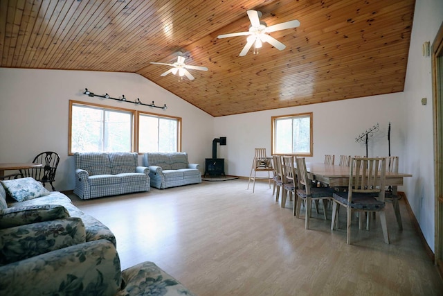 living room with a wood stove, ceiling fan, lofted ceiling, wood ceiling, and wood finished floors