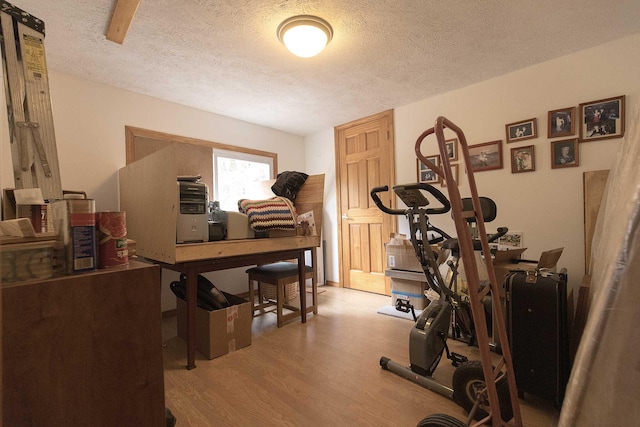 workout room with wood finished floors and a textured ceiling