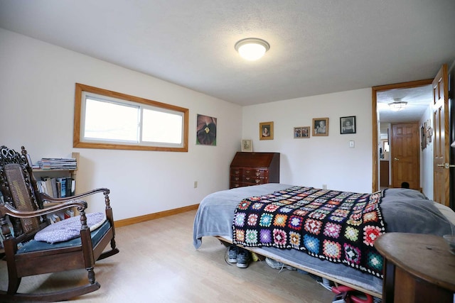 bedroom with wood finished floors and baseboards