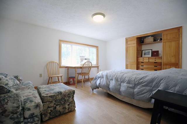 bedroom featuring a textured ceiling and light wood finished floors