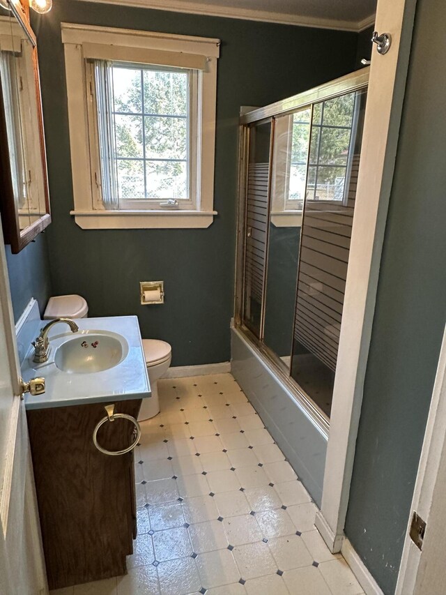 74 Silk St, Brewer, ME 04412 - bathroom featuring healthy amount of natural light, vanity, ornamental molding, and bath / shower combo with glass door