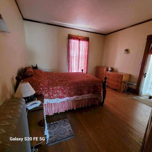 bedroom featuring crown molding and wood finished floors