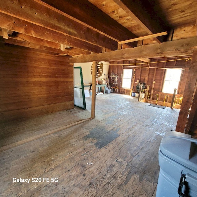 below grade area with wood walls, hardwood / wood-style flooring, and a healthy amount of sunlight