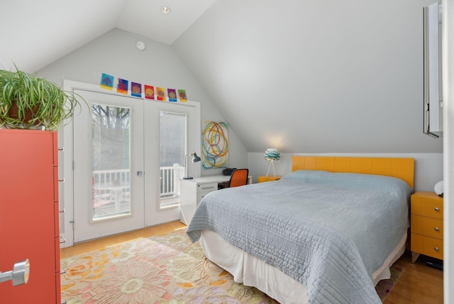 bedroom featuring access to outside, french doors, wood finished floors, and lofted ceiling