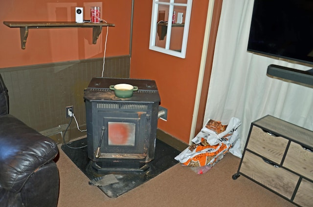 13 Hazen St, Norway, ME 04268 - room details featuring a wood stove, a wainscoted wall, and carpet floors