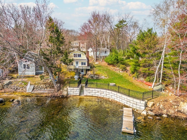 view of dock featuring stairway, a yard, a fenced backyard, and a deck with water view