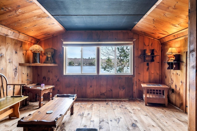 living area featuring wooden walls, wood-type flooring, lofted ceiling, and wooden ceiling