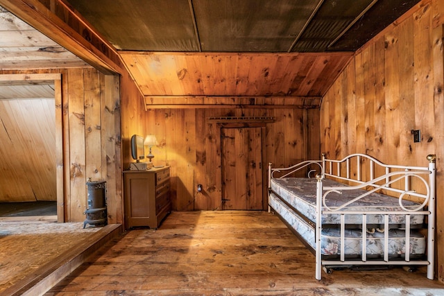 bedroom featuring wood walls and hardwood / wood-style flooring