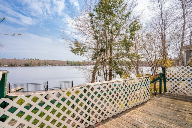 deck featuring fence and a water view