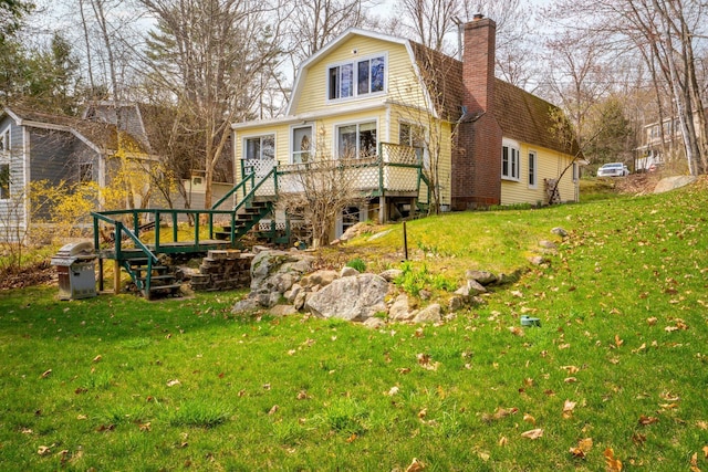 back of house featuring a yard, a wooden deck, a gambrel roof, and stairway