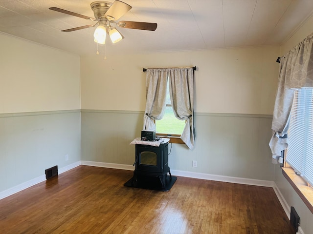 10 Laurette Cir, Caribou, ME 04736 - unfurnished room featuring a wood stove, wood finished floors, ceiling fan, a wainscoted wall, and ornamental molding