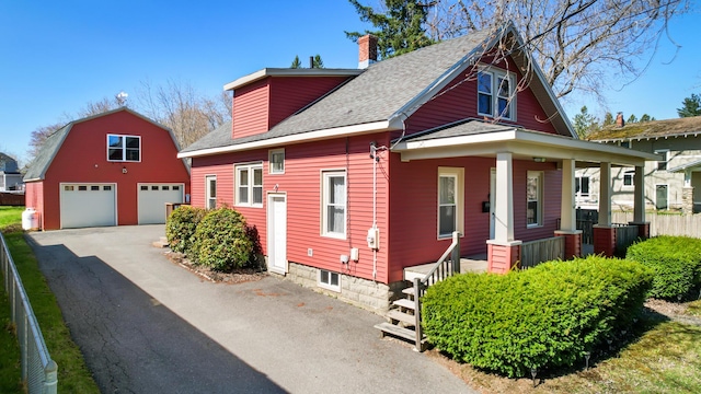 550 Ohio St, Bangor, ME 04401 - view of front of property with a porch, a chimney, an outbuilding, a detached garage, and a shingled roof