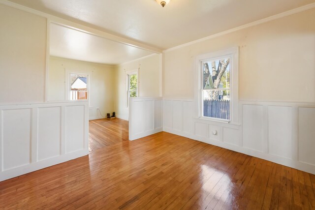 550 Ohio St, Bangor, ME 04401 - spare room featuring light wood-style floors, crown molding, a decorative wall, and a wainscoted wall