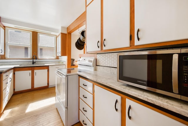 550 Ohio St, Bangor, ME 04401 - kitchen with light wood-style floors, stainless steel microwave, a sink, white electric stove, and backsplash