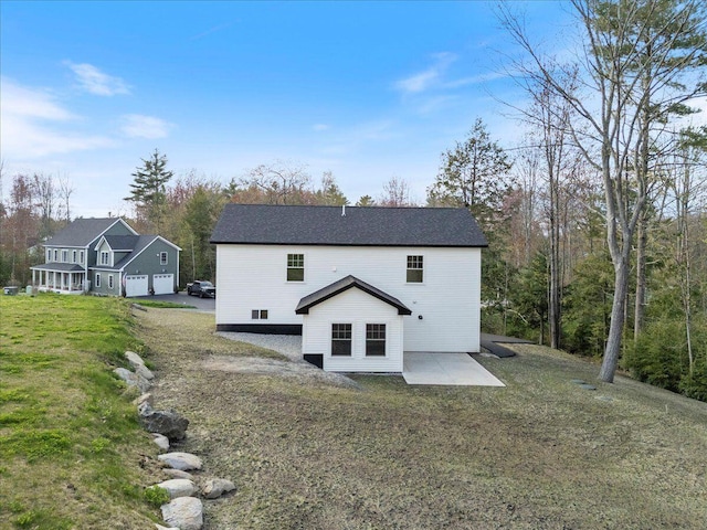 back of house featuring a lawn and a patio