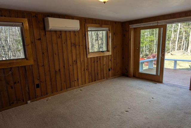 carpeted empty room featuring wooden walls, visible vents, a wall mounted AC, and a healthy amount of sunlight